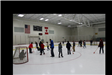 Teens on the ice playing broom ball