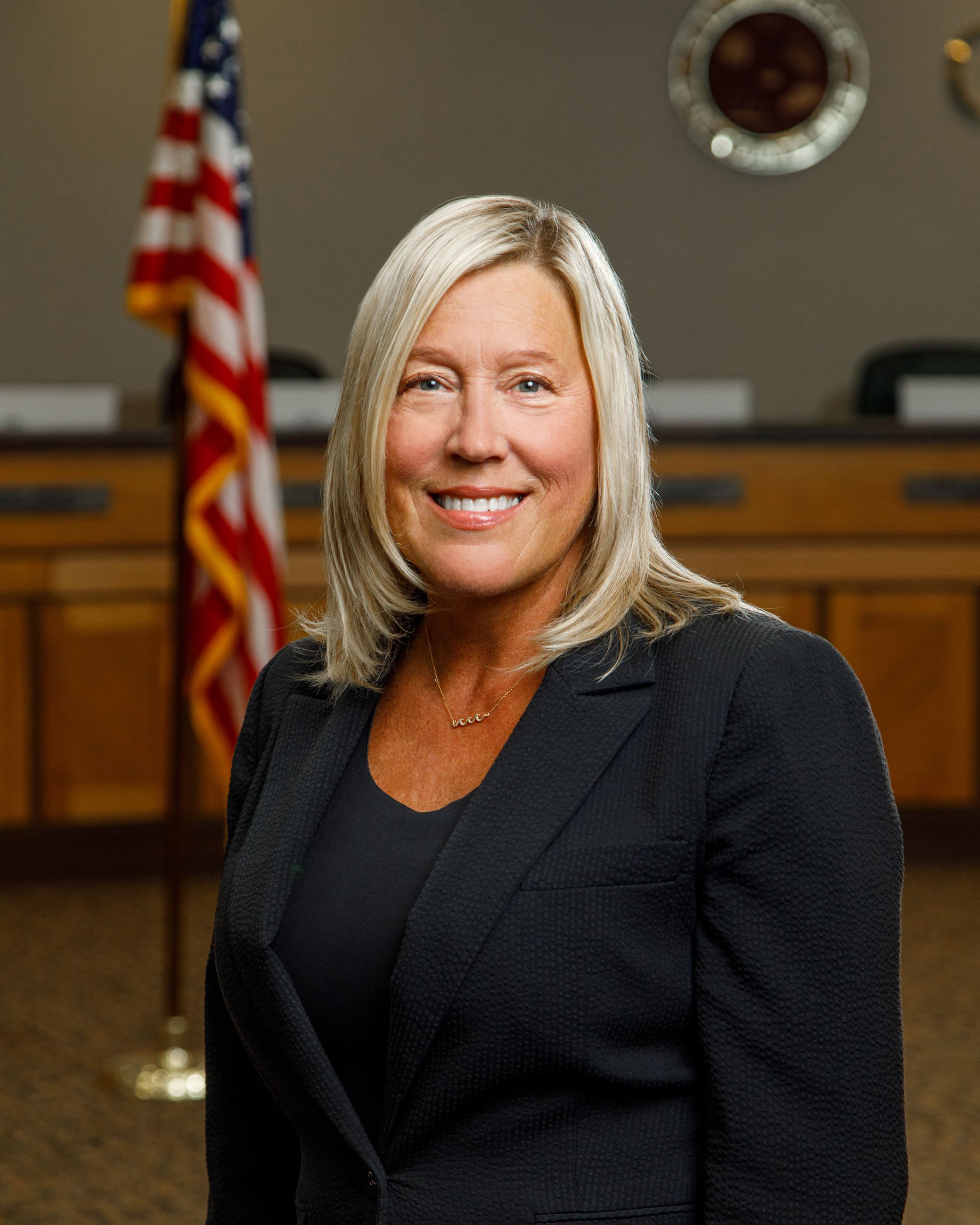 Woman posing with American flag over right shoulder in the background